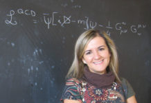 I cervelli che a volte ritornano. Un’astigiana indaga le origini dell’universo Claudia Ratti al Dipartimento di Fisica di Torino: alle sue spalle, sulla lavagna, la formula lagrangiana della teoria delle interazioni forti