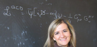 I cervelli che a volte ritornano. Un’astigiana indaga le origini dell’universo Claudia Ratti al Dipartimento di Fisica di Torino: alle sue spalle, sulla lavagna, la formula lagrangiana della teoria delle interazioni forti