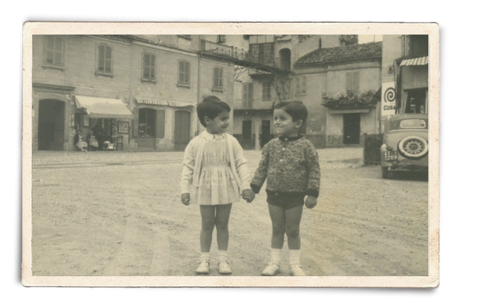 A sinistra Lella Costa bambina a Costigliole con il cugino Fiorenzo. Sullo sfondo la cartoleria-tipografia della nonna